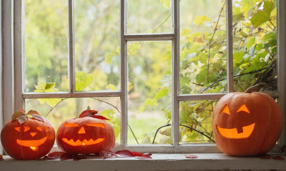 three jack o lanterns on the sill of a window with true divided lites and custom grille pattern