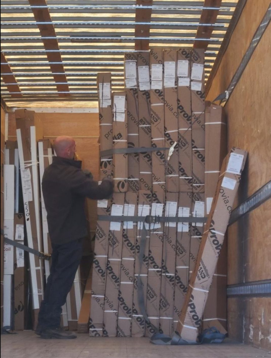 ProVia employee prepares vinyl windows for freight shipping in cardboard boxes