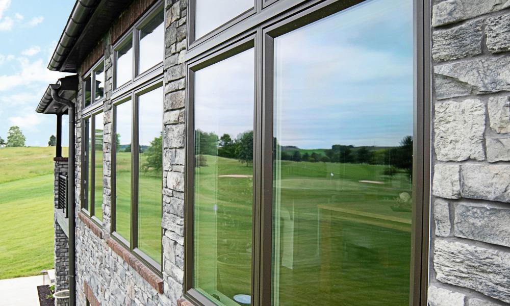 ProVia features black vinyl windows, shown here on a stone front house