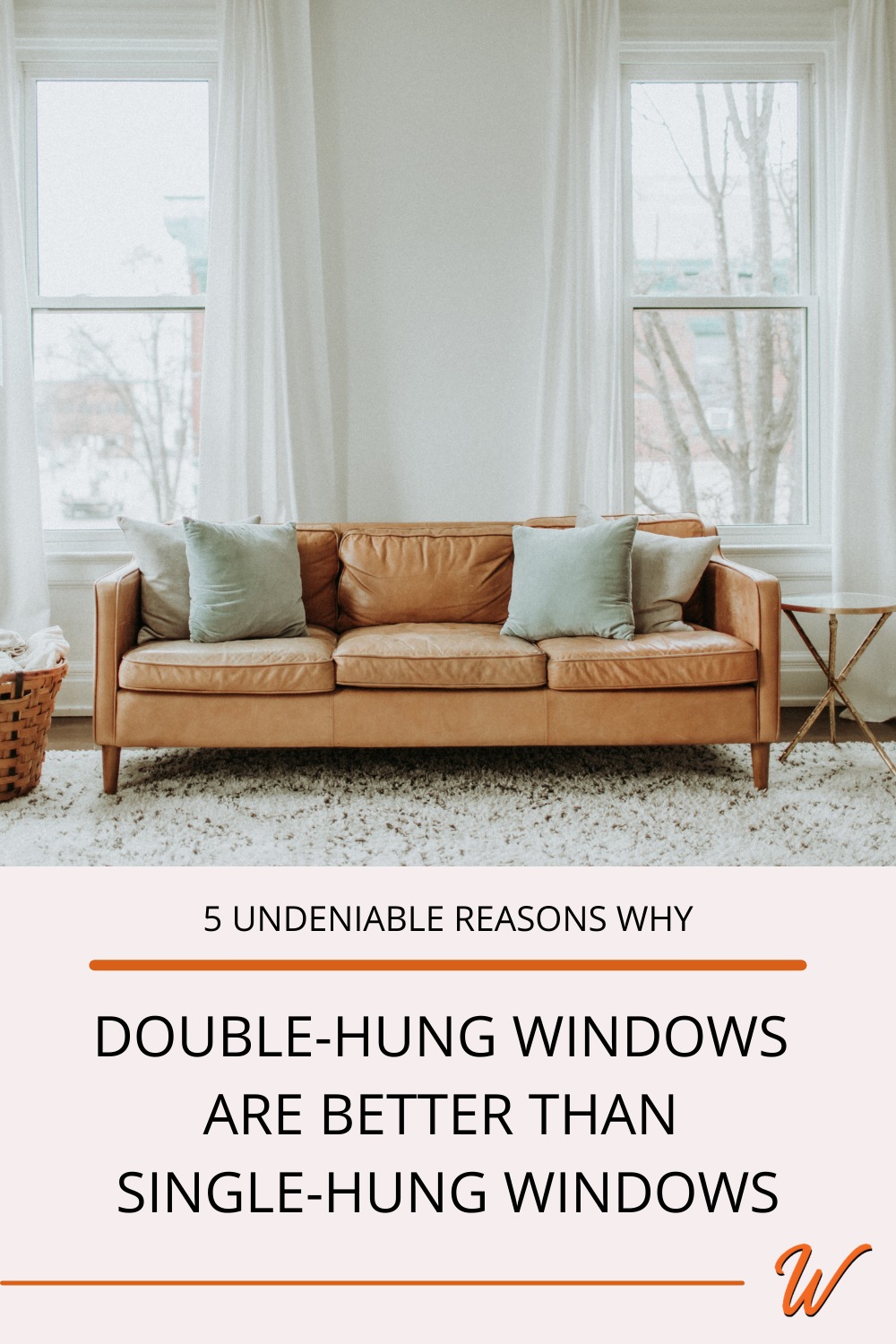 brown midcentury modern couch with pillows in a living room in front of two double hung white windows